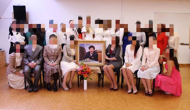 JMS 교주 정명석 사진을 둘러싼 채 신도들이 기념사진을 촬영하고 있다. A씨 제공