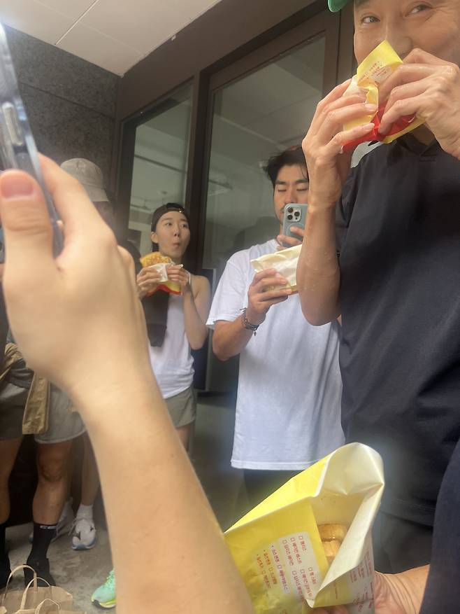 오세훈 시장이 15일 명동의 한 건물 밑에서 비를 피하며 시민들과 함께 토스트를 먹고 있다. 박병국 기자