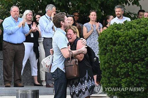 미국 국무부 대규모 감원 (워싱턴DC AFP=연합뉴스) 2025년 7월 11일 미국 국무부에서 대규모 감원으로 해고 통보를 받고 짐을 싸서 나가는 직원들이 오열하면서 껴안는 가운데 동료 직원들이 박수를 치고 있다. (Photo by SAUL LOEB / AFP) 2025.7.15.