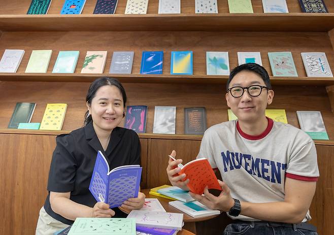 손문경(왼쪽) 아침달 대표와 편집자인 서윤후 시인이 서울 서교동 사무실에서 그간 펴냈던 아침달 시집을 펼쳐 보이고 있다. /조인원 기자