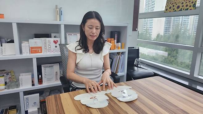 화장품 중소기업 코스모어플러스 고현진 대표가 15일 서울 송파구 본사 사무실에서 자사 리프팅 마스크팩 ‘리브이셀’과 씨제이(CJ)올리브영의 제품을 비교하고 있다. 코스모어플러스 제공