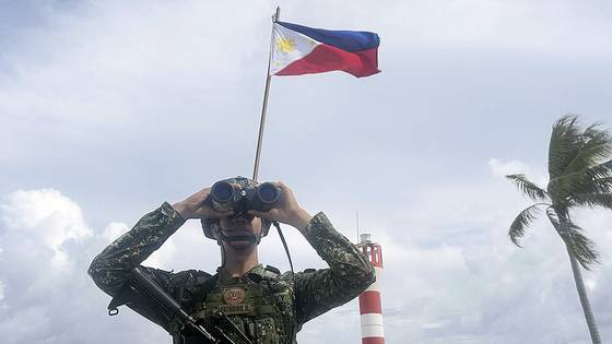 지난달 5일 필리핀이 점유하고 있는 남중국해 웨스트요크섬에 필리핀 국기가 걸려있는 가운데 필리핀 해병대원이 경계 근무를 서고 있다. AP=연합뉴스