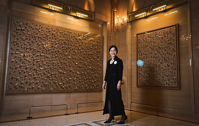 Kim Soo-hyun, owner of The L. Collection at Lotte Hotel Seoul, poses for a photo on July 9 in front of paintings by Kim Tschang-yeul on display at the hotel's executive tower. (Park Hae-mook/The Korea Herald)