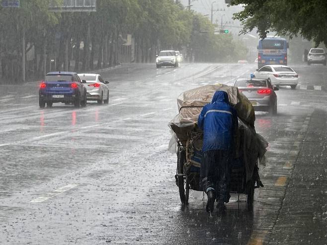 17일 오전 8시 30분쯤 대구 달서구 본리동의 한 왕복 6차선도로에서 최윤성(72)씨가 장대비를 맞으며 아침부터 모은 폐지를 나르고 있다. 구경모 기자