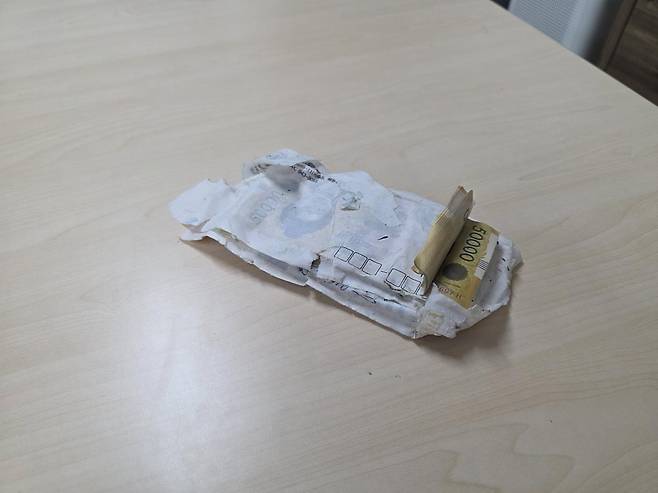 17일 오후 1시 반경 광주 북부소방서 박선홍 소방위 등 구조대원들이 중흥동 전남대 정문 주택가 배수작업을 하다 발견한 현금 봉투. 광주 북부소방서 제공.