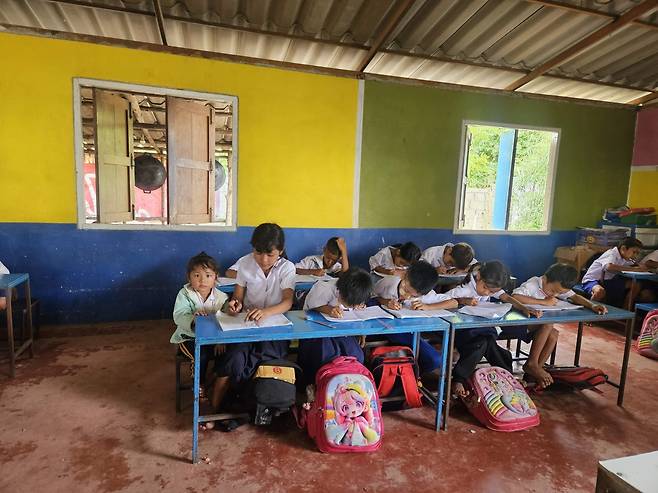 15일 미얀마 접경지역인 태국 매솟의 소오 난민학교에 한 교실의 모습. 수업을 들으러 온 언니 옆에 앉은 아이가 카메라를 응시하고 있다.