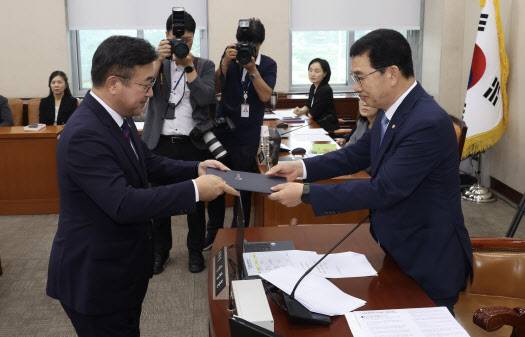 윤호중(왼쪽) 행정안전부 장관 후보자가 18일 서울 여의도 국회 행정안전위원회에서 열린 인사청문회에서 신정훈 행안위원장에게 선서문을 제출하고 있다. (사진=뉴시스)