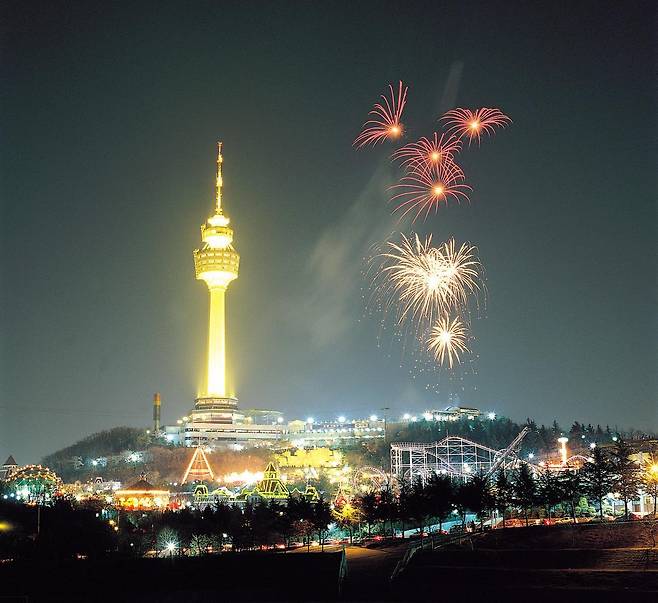 야간 조명이 켜진 83타워 옆에서 불꽃놀이가 펼치지고 있다.