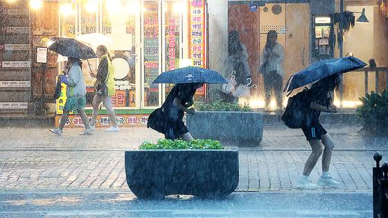 17일 전북 전주시 한옥마을 경기전에서 우산을 쓴 관광객들이 발걸음을 재촉하고 있다. 뉴스1
