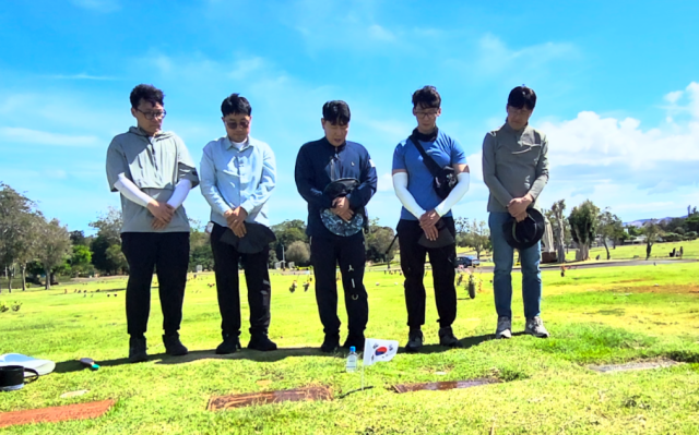 박민원(가운데) 국립창원대학교 총장 등 하와이 이민자 조사단이 지난 6월 현지 조사에서 독립유공자 고덕화·김공도 지사의 묘비를 확인한 후 추모하고 있다. 사진 제공=국립창원대학교