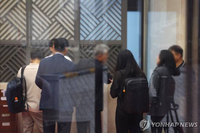 김건희 특검, 통일교 서울 본부 압수수색 (서울=연합뉴스) 김도훈 기자 = 18일 김건희 여사 관련 의혹을 수사하는 민중기 특별검사팀이 압수수색을 실시한 서울 용산구 통일교 서울 본부에서 검찰 관계자들이 직원들과 대화하고 있다.
이날 특검팀은 '건진법사 청탁 의혹'과 관련해 가평에 위치한 통일교 본부와 서울 용산구에 있는 서울 본부에 대한 압수수색을 실시했다. 2025.7.18 superdoo82@yna.co.kr