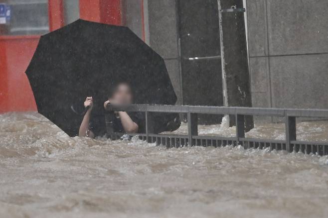 광주지역에 하루 최고 311㎜ 폭우가 쏟아진 지난 17일 오후 침수된 광주 북구청 앞 도로에서 한 시민이 물살에 휩쓸리고 있다. /사진 = 뉴시스