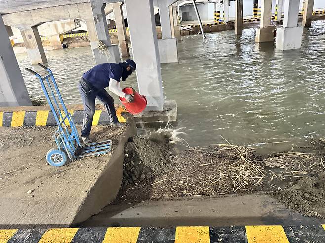 양동 공영주차장 관리소 직원 김석주(60대) 씨가 진흙 등을 광주천에 되돌려 보내고 있다. /임지섭 기자 ljs@namdonews.com