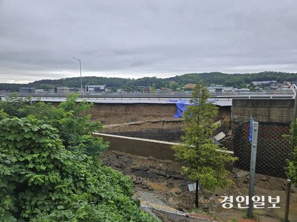 지난 16일 오후 7시께 오산 가장동 서부우회도로의 고가도로 옹벽이 무너지면서 1명이 사망했다. 밤새 내린 비로 복구작업이 중단된 17일 오전, 무너진 옹벽 흙더미 속에 전날 사고의 잔해가 어지럽게 흩어져있다. 2025.7.17 오산/공지영기자 jyg@kyeongin.com