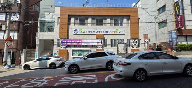 부산 수영구 남천1동행정복지센터 앞 도로 모습. 전용 주차장이 없어 주차된 차량을 피해 운전해야 한다. 박수빈 기자