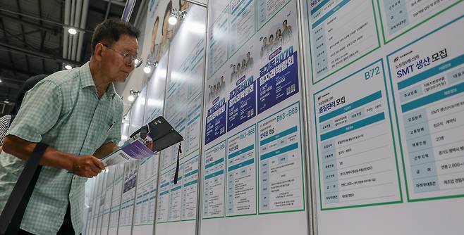 지난 9일 오전 경기 수원시 메쎄에서 열린 경기도 5070일자리 박람회를 찾은 한 장년 구직자가 취업 공고를 살펴보고 있다. /박성원 기자