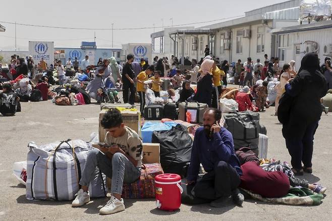 과거 이란으로 떠났다가 강제 추방된 아프가니스탄 난민들이 지난 6월 20일 이란과 인접한 아프가니스탄 서부 헤라트주의 이슬람 칼라 검문소에서 유엔난민기구(UNHCR) 시설 주변에 모여있다.AP뉴시스