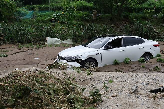 21일 경기도 가평군 대보교 인근 수해 현장에서 차량이 파손되어 있다. 연합뉴스