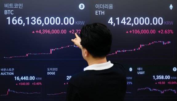 비트코인이 12달러 선을 돌파한 7월 14일 서울 강남구 업비트 고객센터에서 한 고객이 전광판에 뜬 비트코인 시세표를 보고 있다. 동아DB