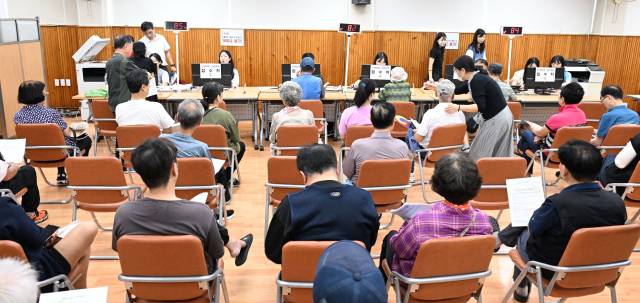 민생회복 소비쿠폰 지급 첫날인 21일 창원시 성산구 사파동 행정복지센터에서 주민들이 신청절차를 밟고 있다./전강용 기자/