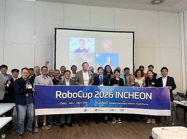 황효진 인천시 글로벌도시정무부시장이 20일 브라질 살바도르에서 열린 ‘로보컵 2025’ 폐막식에서 대회기를 인수한 뒤 관계자들과 기념 촬영하고 있다. (사진 = 인천시 제공)