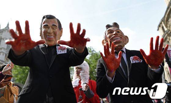 2016년 7월 6일(현지시간) 영국 런던 '퀸 엘리자베스 2세 컨퍼런스 센터(QEII Centre) 밖에서 토니 블레어 전 영국 총리와 조지 W 부시 전 미국 대통령의 가면을 쓴 시위대가 이라크전쟁 관련 보고서 발표를 기다리고 잇다. ⓒ AFP=뉴스1 ⓒ News1 최종일 기자