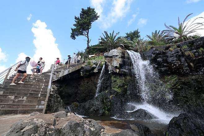 22일 오전 제주 서귀포시 토평동 소정방폭포를 찾은 관광객이 시원한 물줄기를 감상하고 있다. /연합뉴스