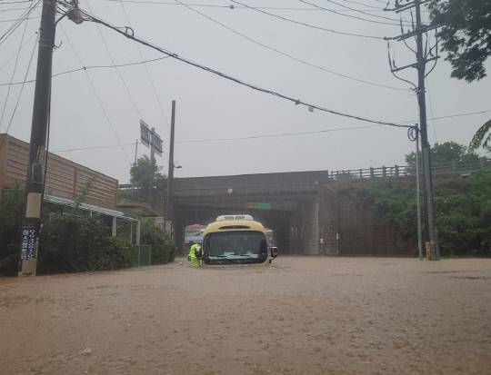 지난 17일 새벽 6시53분쯤 천안시 성환읍 우신리의 한 도로에서 시내버스가 침수돼 있다. 이날 성황파출소 경찰관들은 이 버스의 문을 강제로 개방해 버스에 갇혀있던 50대 버스기사를 구조했다. 천안서북경찰서 제공