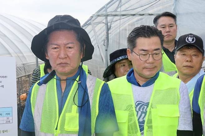 정청래·박찬대 더불어민주당 당대표 후보(왼쪽부터)가 21일 충남 예산군 신안면 조곡리 수해복구 현장에서 최재구 예산군수로부터 피해 현황을 듣고 있다. ⓒ뉴시스