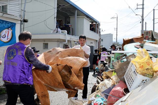 ▲ 지난 20일 광주 북구 신안교 인근 도로에서 자원봉사자들이 침수된 주택에서 나온 장판을 옮기고 있다. 연합뉴스