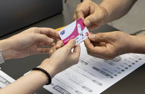 21일 부산의 한 행정복지센터에서 시민이 민생 회복 소비쿠폰 선불카드를 수령하고 있다. 전민철 기자 jmc@kookje.co.kr