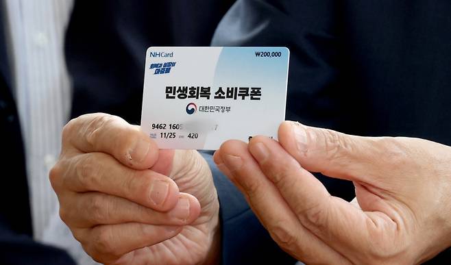 구윤철 경제부총리 겸 기획재정부 장관이 21일 오후 민생회복 소비쿠폰 시행 첫날 충남 공주시 산성시장을 방문 과일가게등 재래시장 소비쿠폰 사용을 점검하며 소비쿠폰으로 과일을 구매하러 나온 시민의 카드를 들어 보이고 있다/사진=뉴스1