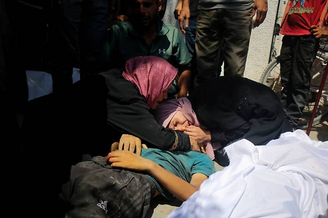 20일(현지시간) 팔레스타인 주민들이 가자 북부에서 구호품을 기다리다 이스라엘군의 총격으로 숨진 희생자를 끌어안고 있다. /로이터=뉴스1