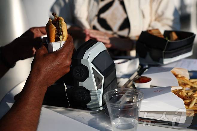 21일(현지시간) 미국 로스엔젤레스에서 열린 테슬라 다이너 앤 드라이브인 레스토랑과 슈퍼차저 개장식에서 시민들이 식사를 하고 있다.ⓒ AFP=뉴스1