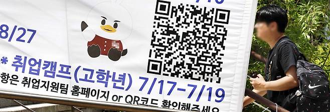 22일 서울의 한 대학 캠퍼스에 걸려 있는 취업지원 안내 현수막 앞으로 대학생이 걸어가고 있다. 김호영 기자