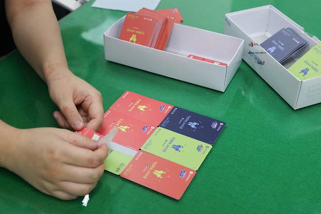 행정복지센터 직원이 24일 광주시 동구의 한 행정복지센터에서 민생회복 소비쿠폰 선불카드에 스티커를 부착하고 있다. 광주 동구 제공