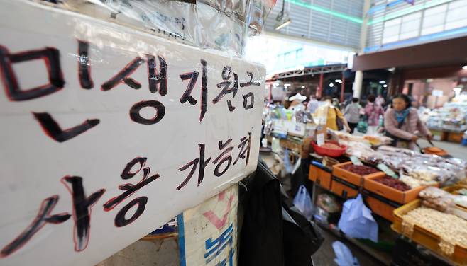 25일 오후 서울 동대문구 청량리종합시장에 민생회복 소비쿠폰 사용가능 점포 안내문이 붙어 있다. / 뉴스1