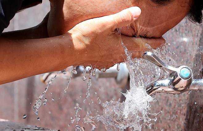 지난 22일 대구 중구 달성공원에 설치된 음수대에서 한 시민이 세수를 하고 있다. 뉴시스