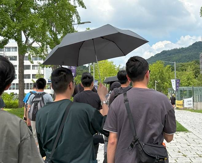 '같이 쓰자', 두 명이 나란히 쓴 양산 (서울=연합뉴스) 최혜정 인턴기자 = 지난 23일 오후 남성 두 명이 양산 1개를 나눠 쓰고 있다. 2025.7.25