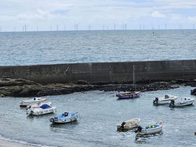 프랑스 바츠쉬르메르에서 본 생나제르 해상풍력단지 전경. 해안가 앞 작은 어선들 뒤로 해상풍력단지가 넓게 뻗어 있다. 전진영 기자.