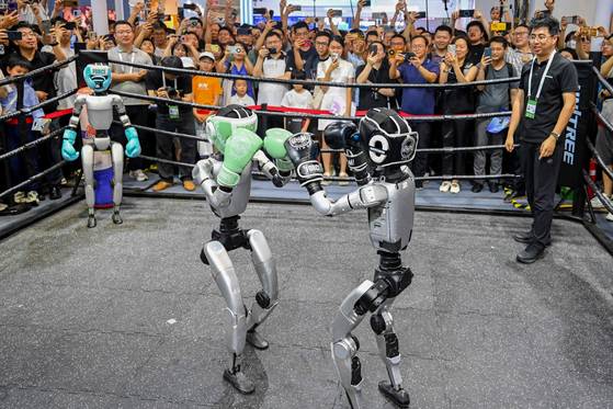 26일 상하이에서 열린 2025 세계 인공지능 대회(WAIC) 전시회장에서 휴머노이드 로봇이 권투 경기를 펼치고 있다. AFP
