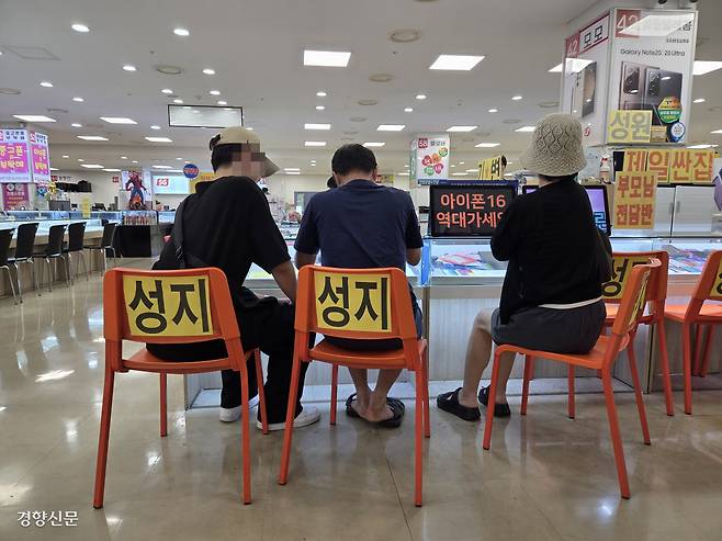 한산한 ‘휴대폰 성지’ 27일 신도림테크노마트 휴대전화 집단상가를 찾은 한 가족이 계약서를 작성하고 있다.