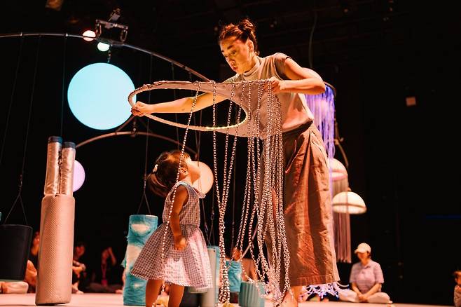 25일 서울 종로구 대학로예술극장 소극장에서 열린 ‘내가 처음 만난 우주’는 24개월 이하 영아와 보호자만을 대상으로 한 체험공연이다. 배우들은 돌을 굴리고, 끈을 찰랑여 보이면서 어린 관객의 오감을 자극했다. 국제아동청소년연극협회 제공