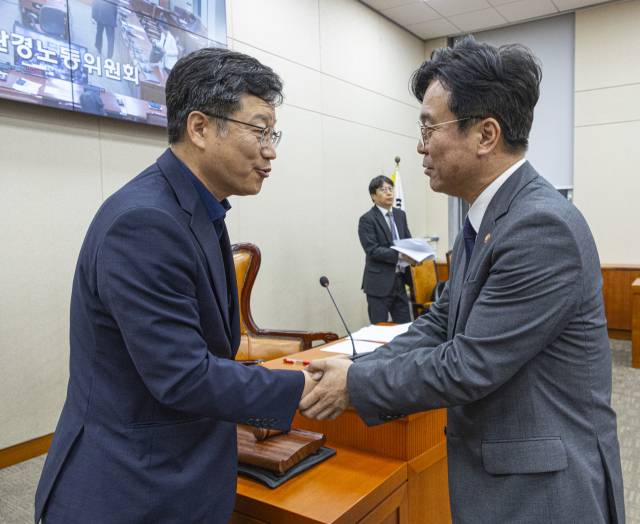 국회 환경노동위원회 안호영(왼쪽) 위원장과 김영훈 고용노동부 장관이 28일 윤석열 전 대통령이 거부권(재의요구권)을 행사했던 '노란봉투법'(노조법 2·3조 개정안)이 국회 환경노동위원회에서 통과된 뒤 악수하고 있다. 이날 노조법 2·3조 개정안은 이날 소위를 통과한 뒤 환노위 전체회의에서 국민의힘 의원들이 퇴장한 가운데 처리됐다. 연합뉴스