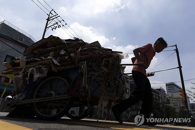 폭염 (서울=연합뉴스) 윤동진 기자 = 폭염이 이어지고 있는 28일 서울 동대문종합시장 인근에서 한 어르신이 폐지를 실은 손수레를 끌고 있다. 2025.7.27 mon@yna.co.kr