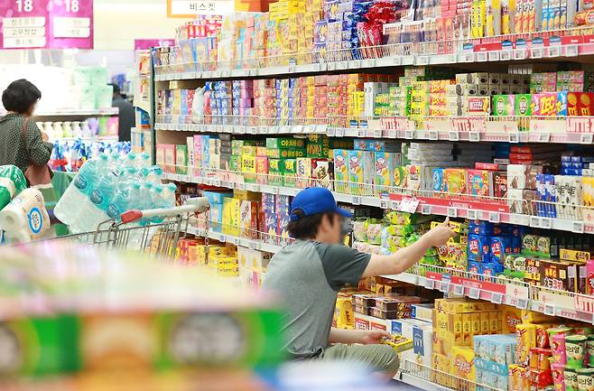 서울의 한 대형마트 과자 판매대에서 소비자들이 과자를 고르고 있다. /연합뉴스