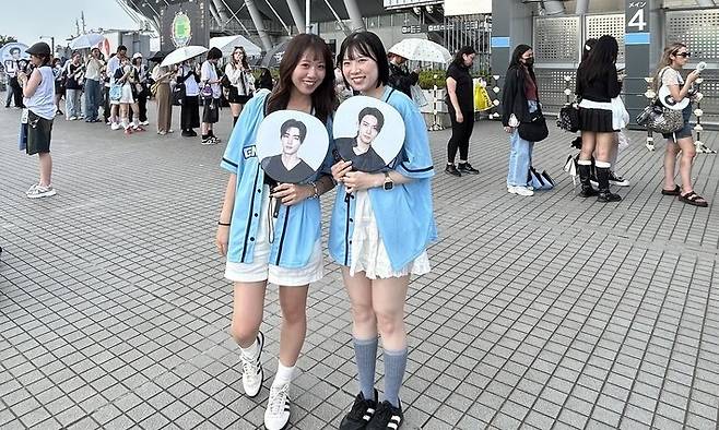 지난 6일 케이팝 그룹 ‘엔하이픈’의 대형 콘서트가 열린 일본 도쿄 아지노모토 경기장에서 일본 팬들이 멤버들의 사진을 들고 입장을 기다리고 있다. 도쿄/홍석재 특파원