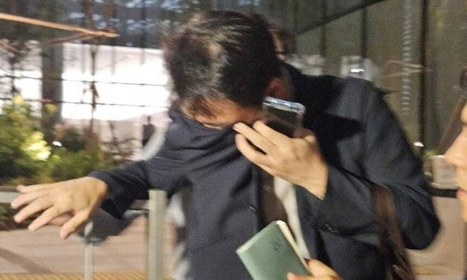 김건희 여사 오빠인 김진우씨가 28일 밤 김 여사 관련 의혹들을 수사하는 민중기 특별검사팀 사무실이 위치한 서울 종로구 케이티(KT)광화문빌딩웨스트(West)에서 조사를 마친 뒤 얼굴을 가린 채 특검 사무실을 나서고 있다. 연합뉴스