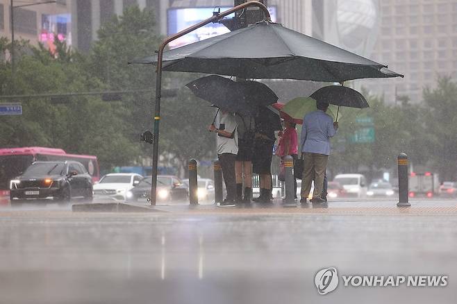 빗속에 갇힌 시민들 (서울=연합뉴스) 서대연 기자 = 서울 전역에 호우주의보가 내린 20일 서울 종로구 광화문 네거리에서 우산을 쓴 시민들이 신호를 기다리고 있다. 2025.6.20 dwise@yna.co.kr