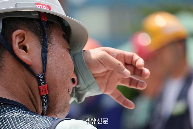 건설노조가 지난 7월 29일 서울 종로구 국정기획위원회 앞에서 연 폭염 실태 기자회견에서 한 조합원이 안전모를 쓴 채 땀을 흘리고 있다. 김창길 기자